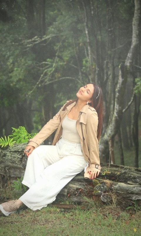 Priscila Flores sentada en un bosque